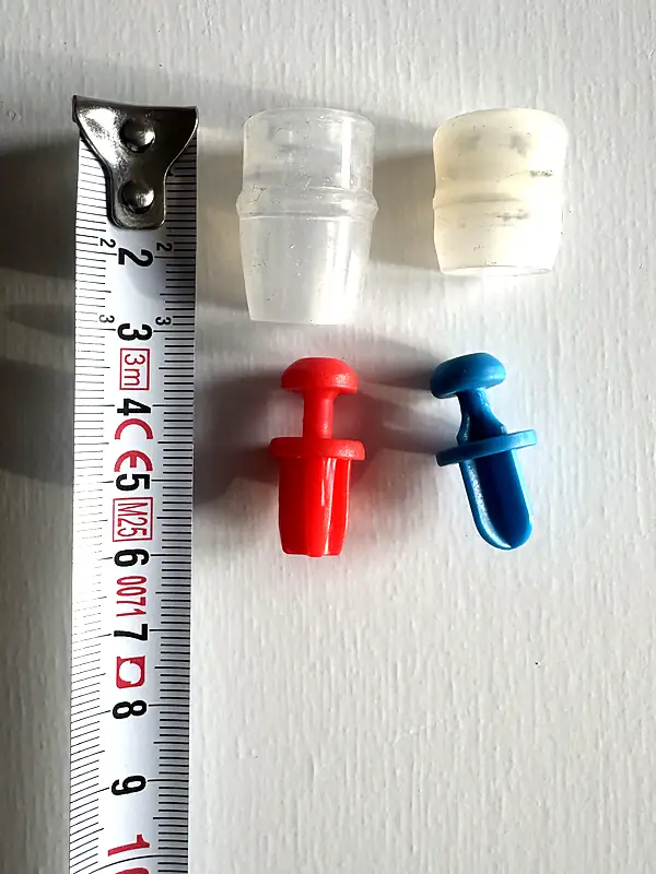 Replacement bite valve sheaths and valves for a hydration bladder and soft flask next to a tape measure